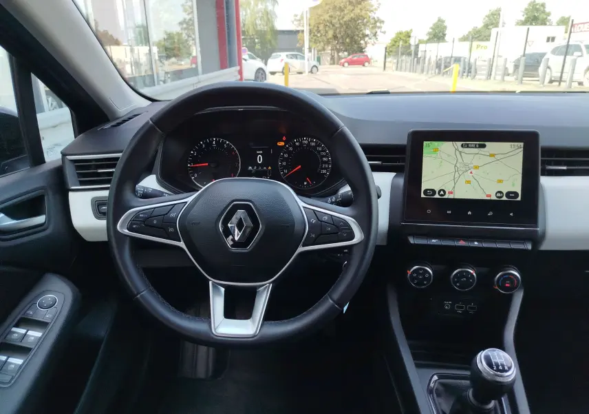 Vue intérieure frontale du poste de conduite de la Renault Clio Bleu Iron 2022 avec volant multifonction et écran tactile central.