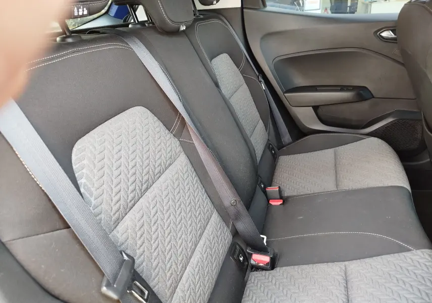 Vue intérieure des sièges arrière gris et noirs de la Renault Clio 1.0 SCe 65ch Evolution, avec ceintures de sécurité visibles.