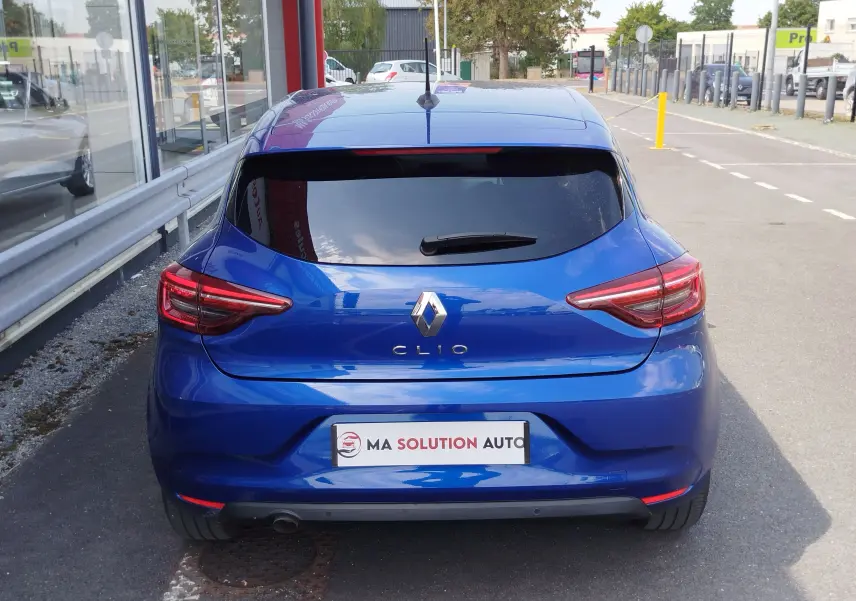 Vue arrière d'une Renault Clio 2022 bleu Iron, avec feux arrière LED et vitre arrière teintée.