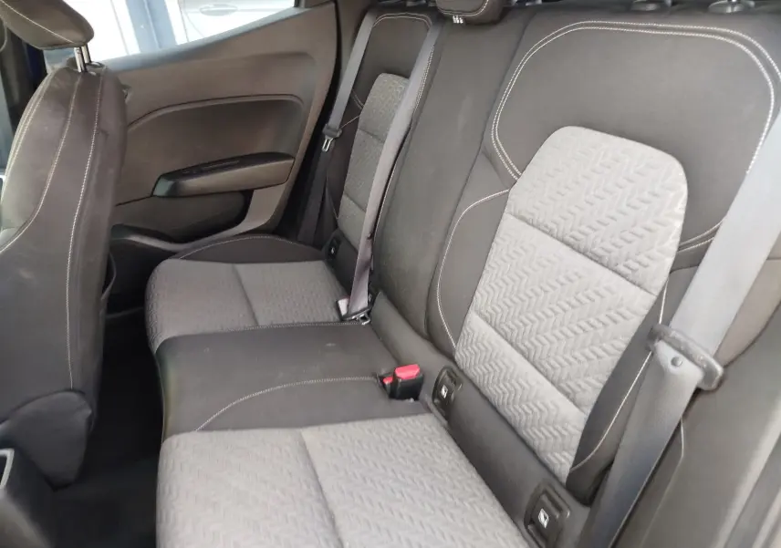 Vue intérieure des sièges arrière gris clair et foncé de la Renault Clio 2022, avec ceinture de sécurité et texture en relief.