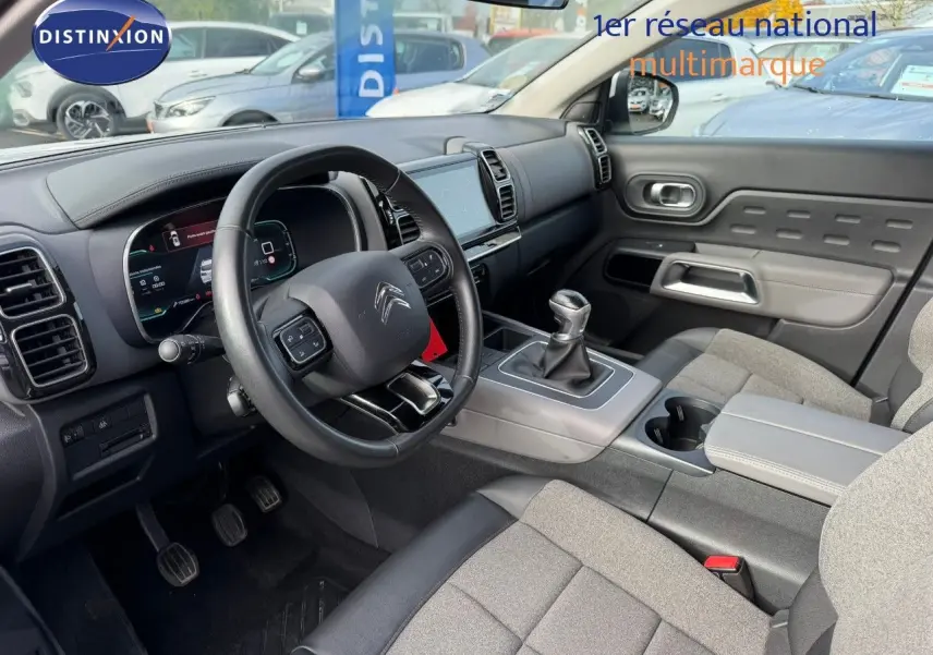 Intérieur du Citroën C5 Aircross 2019, vue côté conducteur, volant cuir, tableau de bord numérique et levier manuel.
