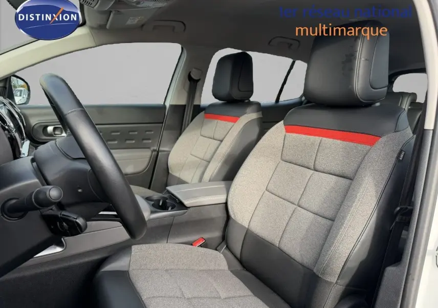 Vue intérieure côté conducteur du Citroën C5 Aircross blanc nacré, sièges gris avec bande rouge et cuir noir.