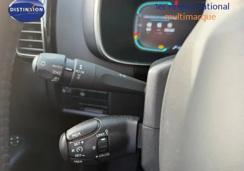 Gros plan sur les commandes au volant du Citroën C5 Aircross blanc nacré, mettant en valeur les réglages de vitesse et phares.