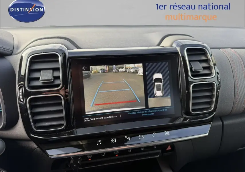 Vue rapprochée de l'écran multimédia affichant la caméra de recul dans l'habitacle noir du Citroën C5 Aircross blanc nacré.