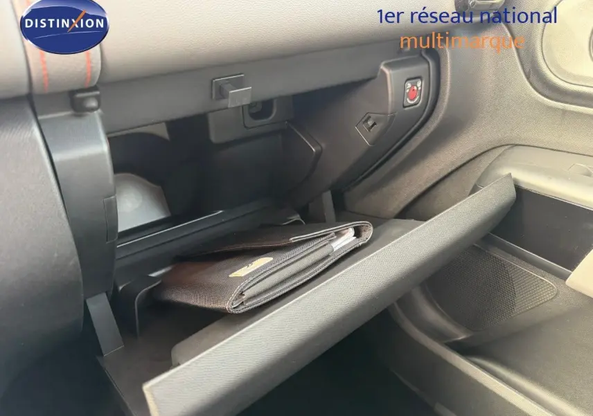 Gros plan de la boîte à gants ouverte côté passager du Citroën C5 Aircross blanc nacré avec un porte-documents noir à l'intérieur.