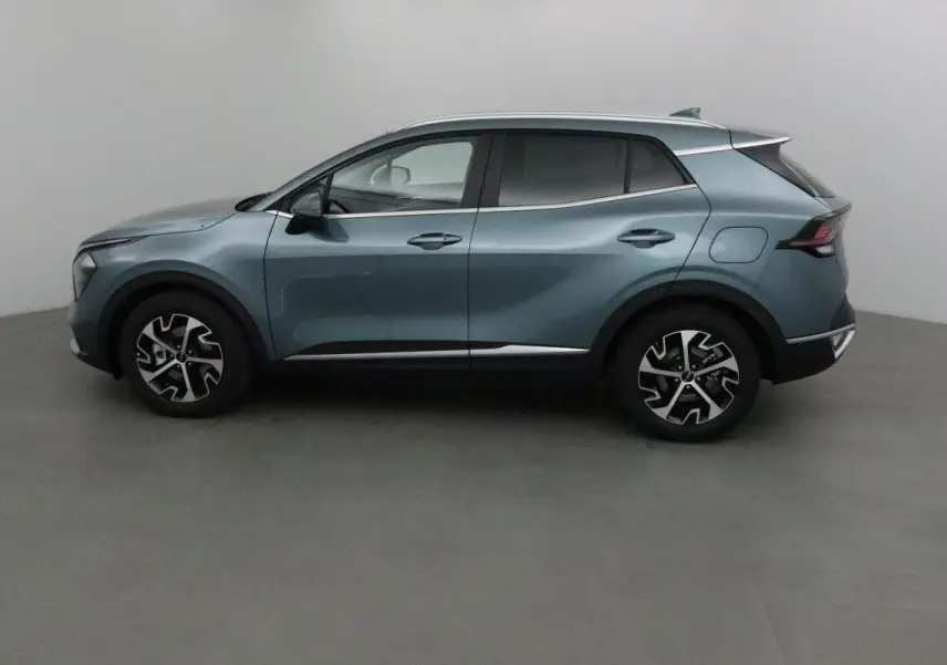 Profil côté gauche du SUV KIA SPORTAGE gris Sirius 2025 avec jantes alliage bicolores et lignes modernes.