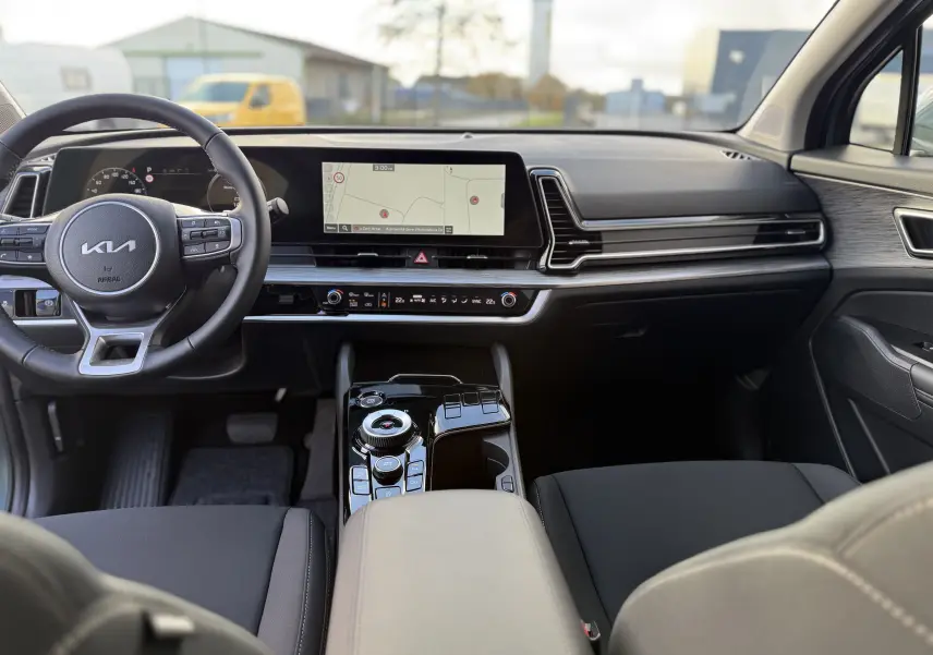 Écran central du Kia Sportage 2025 montrant la caméra de recul avec lignes de guidage et détection d'obstacles.