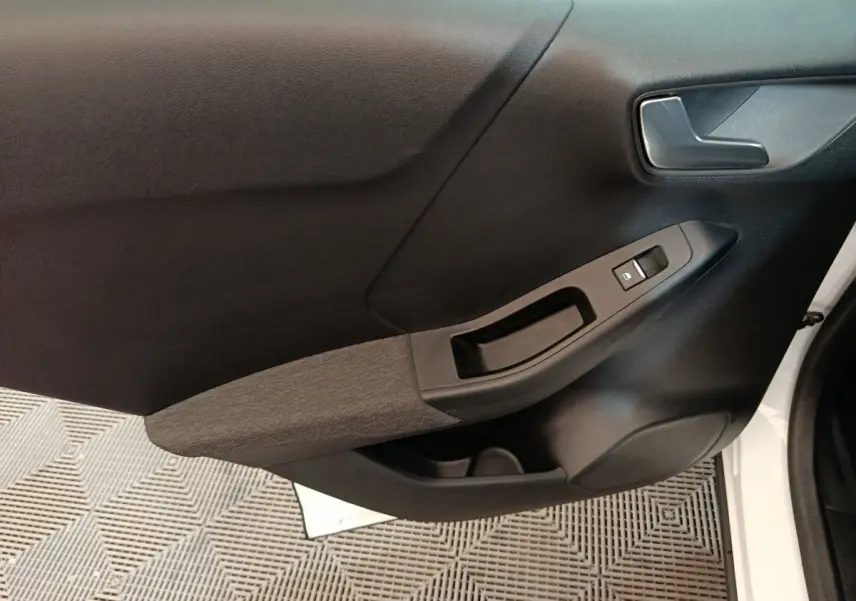 Gros plan sur la porte avant droite blanche du Ford Puma 2022, avec poignée intérieure et commandes de vitre noires.