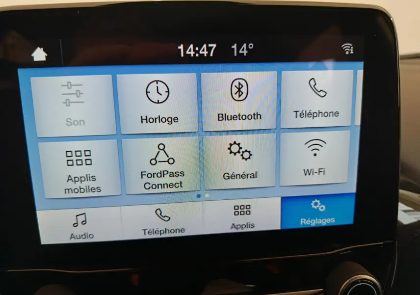 Écran tactile central affichant le menu des réglages dans l’habitacle d’une Ford Puma blanche, vue de face.