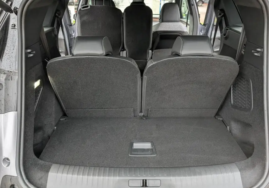 Vue arrière du coffre du Peugeot 5008 gris avec banquette 3e rang rabattue et sièges 2e rang visibles.
