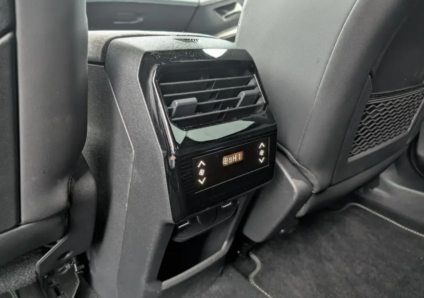 Détail de la console centrale arrière avec commandes de climatisation et prises USB dans l’habitacle noir du Peugeot 5008 gris.