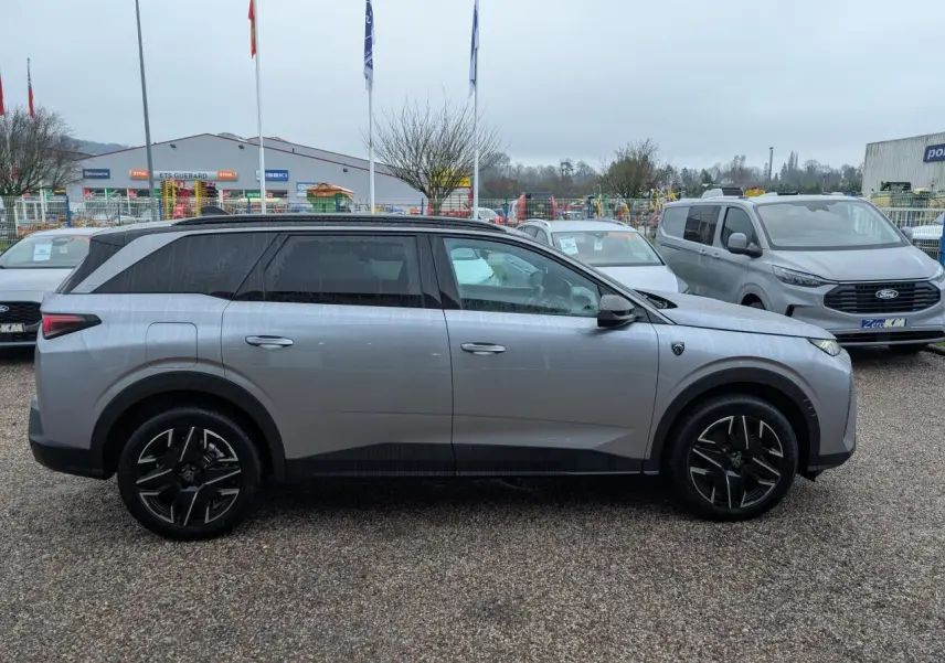 Peugeot 5008 gris métallisé vue de profil côté gauche, avec jantes alliage noires et toit noir.