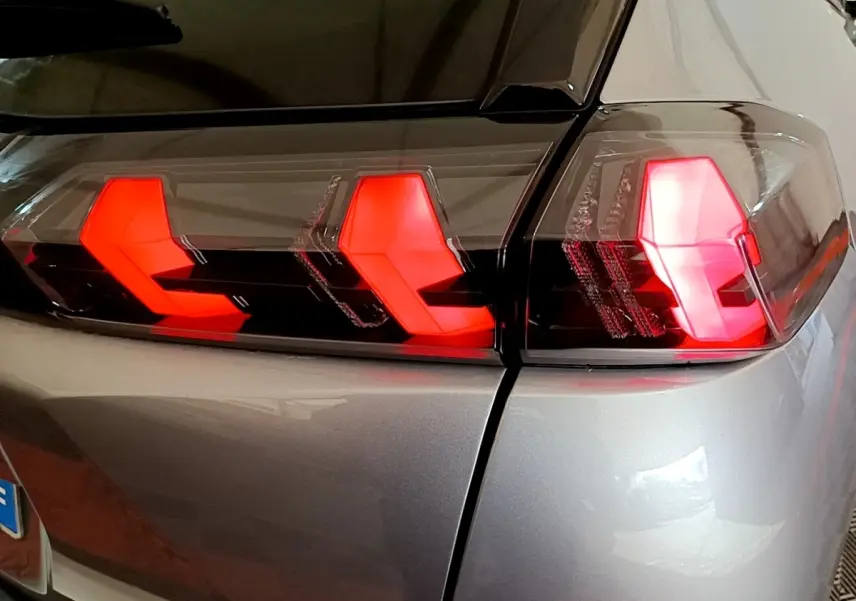 Gros plan sur le feu arrière droit rouge du Peugeot 2008 gris clair, soulignant la finition moderne du modèle 2021.