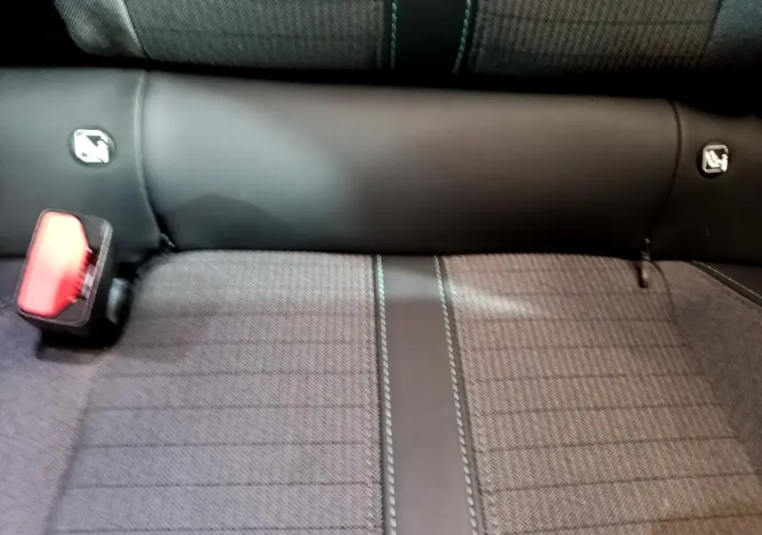 Gros plan sur la banquette arrière gris foncé du Peugeot 2008 avec ceinture de sécurité rouge visible à gauche.