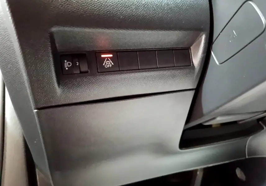 Détail intérieur montrant les commandes d'assistance à la conduite avec bouton désactivation sur Peugeot 2008 gris clair.