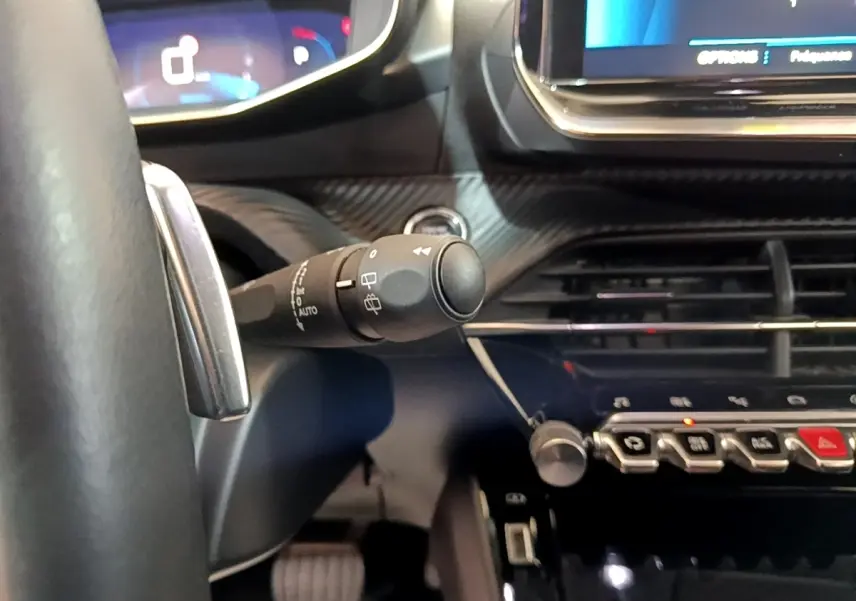 Gros plan sur la commande d’essuie-glace à gauche du volant dans l’habitacle gris clair du Peugeot 2008 2021.