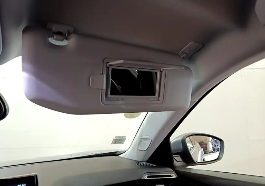 Détail intérieur du pare-soleil côté conducteur avec miroir éclairé sur Peugeot 2008 gris clair, vue depuis l’habitacle.