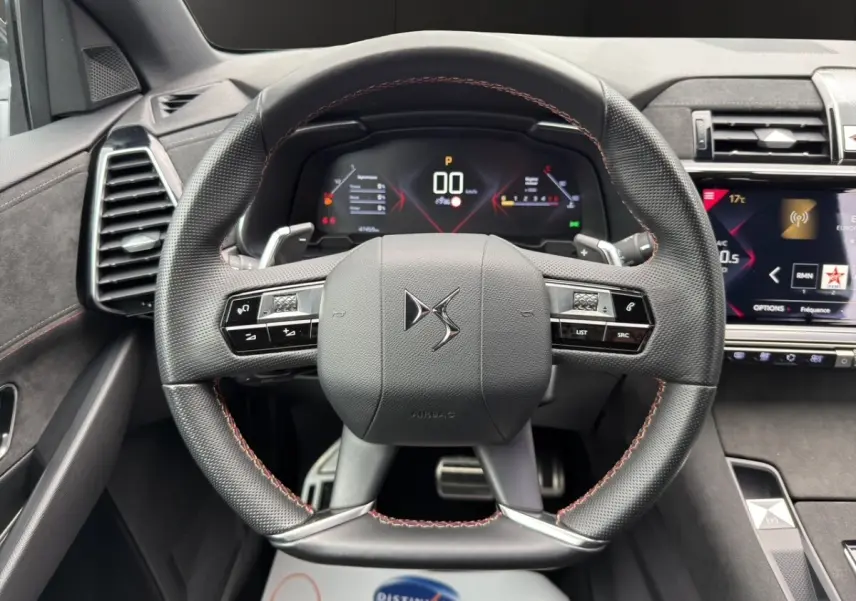 Vue frontale du volant cuir noir avec surpiqûres rouges du DS7 Crossback 2022, tableau de bord digital et écran tactile visibles.