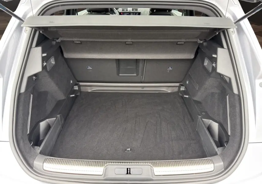 Coffre ouvert vu de l'arrière d'un DS7 Crossback gris clair, montrant un espace de chargement propre et bien agencé.