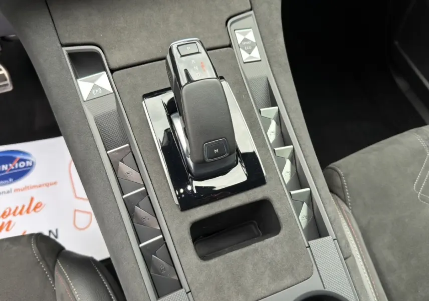 Vue rapprochée de la console centrale grise du DS7 Crossback 2022, avec levier de vitesse automatique et boutons multifonctions.