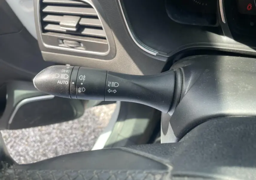 Gros plan sur la commande des phares et clignotants dans l’habitacle d’une Renault Mégane IV blanche de 2016.