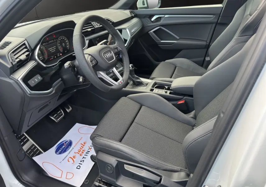 Intérieur noir de l'Audi Q3 Sportback S line 2024 vu côté conducteur avec volant multifonction et sièges sport.