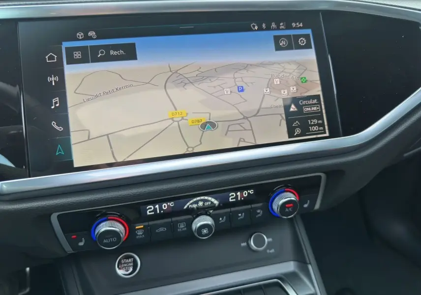 Détail de la console centrale avec écran de navigation et commandes de climatisation du Audi Q3 Sportback blanc 2024.