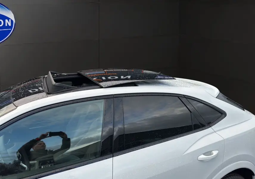 Vue latérale gauche d'un Audi Q3 Sportback blanc avec toit ouvrant panoramique et vitres surteintées.