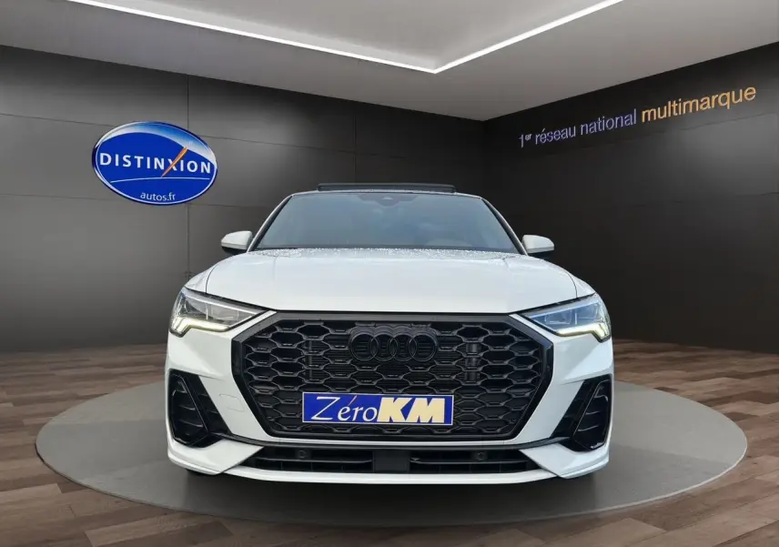 Audi Q3 Sportback blanc vue de face avec calandre noire hexagonale et phares LED allumés