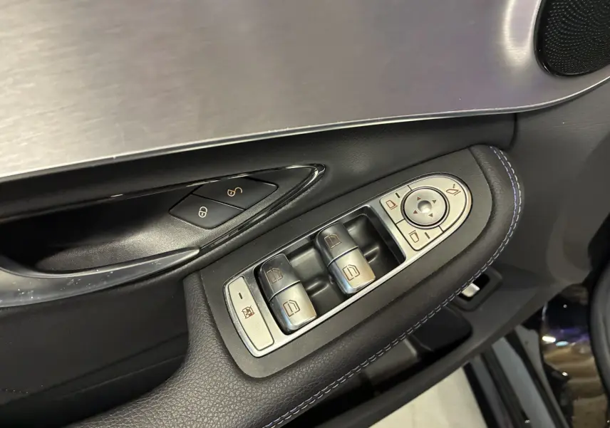 Gros plan sur les commandes de lève-vitres et rétroviseurs côté conducteur du Mercedes Classe C Break noir métal 2021 AMG Line.