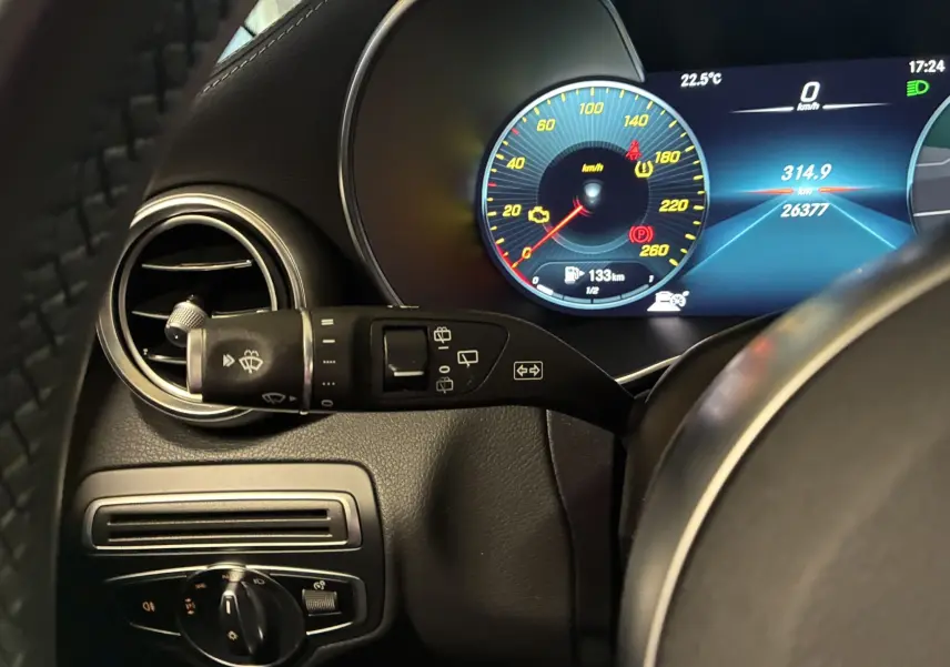 Gros plan sur le combiné d'instruments numérique et commande d'essuie-glace dans l'habitacle noir du Mercedes Classe C Break AMG Line 220D.