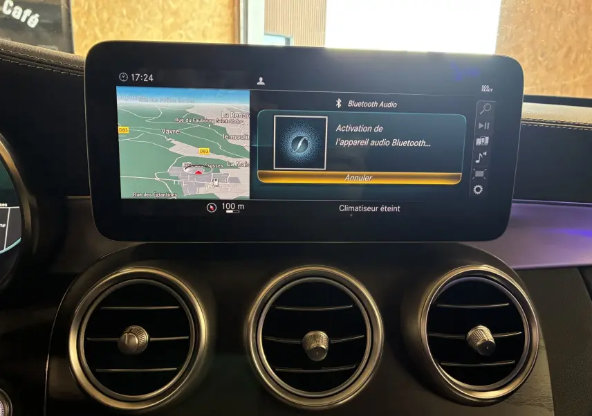 Écran tactile central du tableau de bord d'une Mercedes Classe C Break 220D noir, affichant navigation et Bluetooth.