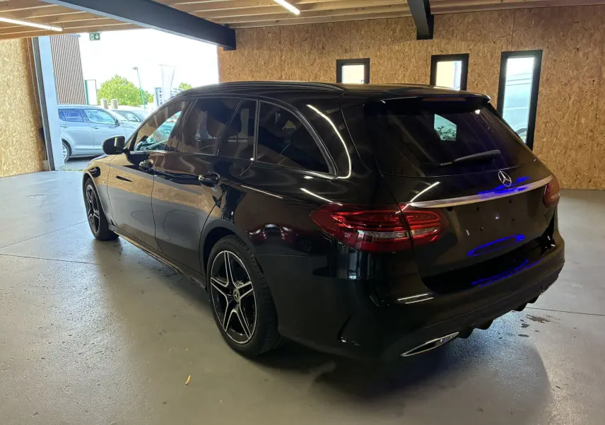 Mercedes Classe C Break 220D noir métal vue 3/4 arrière droit, vitres surteintées et jantes AMG 18 pouces bi-ton.