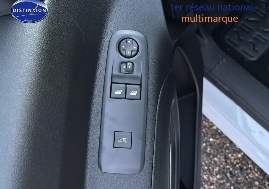 Vue rapprochée de la porte avant gauche blanche du Citroën Berlingo Fourgon avec commandes électriques des vitres et rétroviseurs.