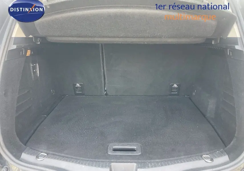 Coffre ouvert d’un Renault Scénic IV noir, montrant un espace de chargement propre et spacieux.