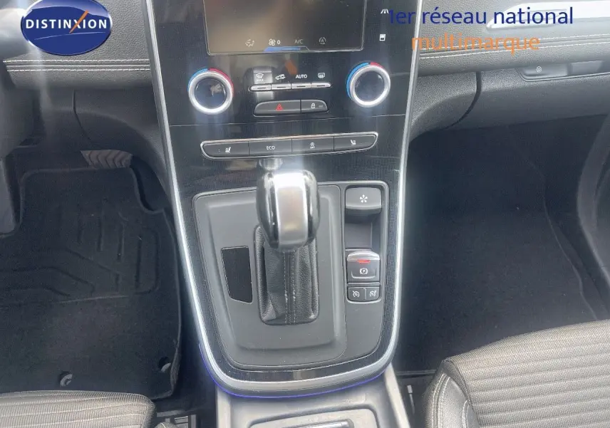 Gros plan sur la console centrale du Renault Scénic IV noir, mettant en valeur la boîte automatique et les commandes de climatisation.