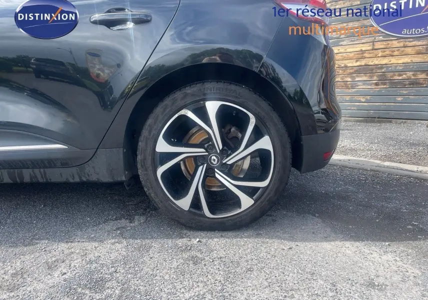 Vue latérale arrière gauche du Renault Scénic IV noir, mettant en valeur la jante alliage au design moderne.