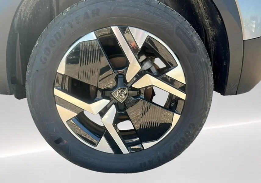 Gros plan sur la jante alu bicolore noire et argentée du côté avant droit du Peugeot 2008 gris artense.