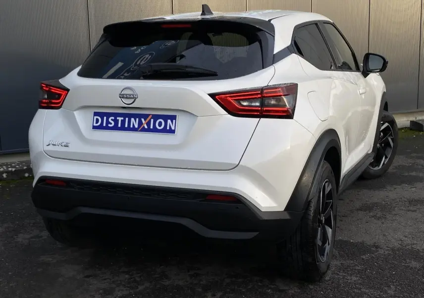 Vue 3/4 arrière droite du Nissan Juke blanc perle avec feux arrière LED et jantes alliage noires.