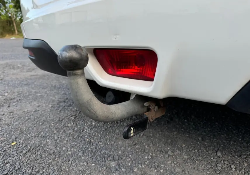 Gros plan sur l'attelage d'une SsangYong Tivoli blanc 2016 avec feu arrière rouge visible sur le côté droit arrière.