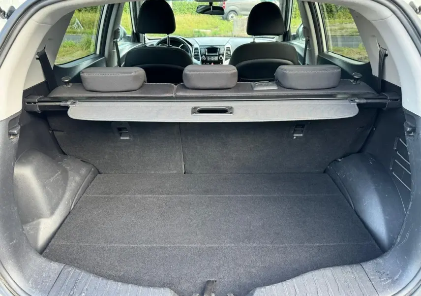 Coffre ouvert du SsangYong Tivoli blanc 2016, vue arrière montrant l'espace de chargement et les sièges arrière rabattus.