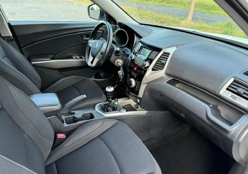 Intérieur noir du Ssangyong Tivoli 2016 vu côté conducteur, avec tableau de bord et levier de vitesse manuel visibles.