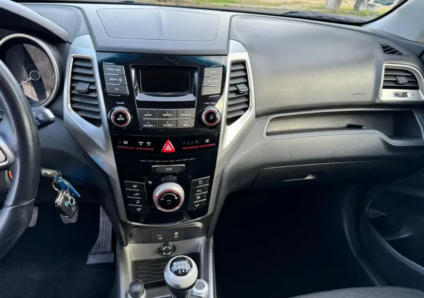 Intérieur du SsangYong Tivoli 2016, vue centrale du tableau de bord avec console noire et levier de vitesse manuel.