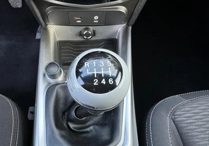 Gros plan sur le levier de vitesses manuel du SsangYong Tivoli blanc 2016 avec prises USB et AUX visibles.