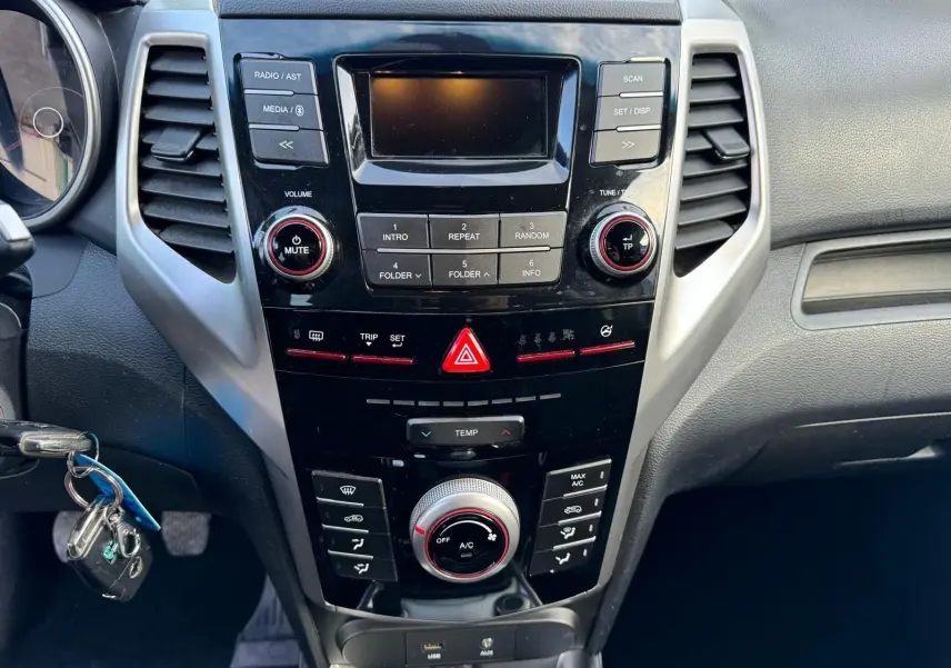 Vue rapprochée du tableau de bord noir du SsangYong Tivoli 2016 avec commandes audio et climatisation.