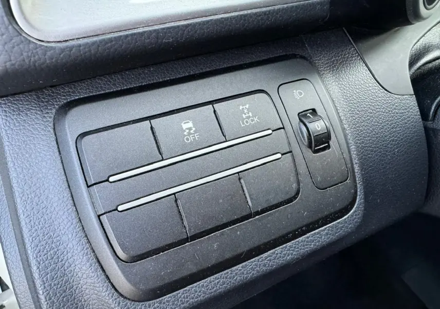 Gros plan sur les commandes de traction et verrouillage 4x4 dans l'habitacle noir du SsangYong Tivoli blanc 2016.