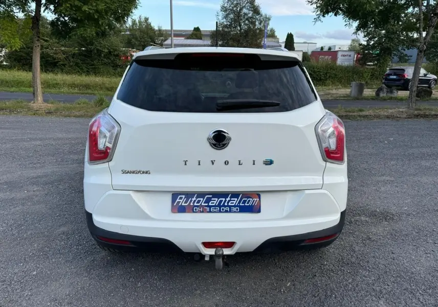 Vue arrière d'un SsangYong Tivoli blanc 2016 avec attelage visible sur un parking extérieur.