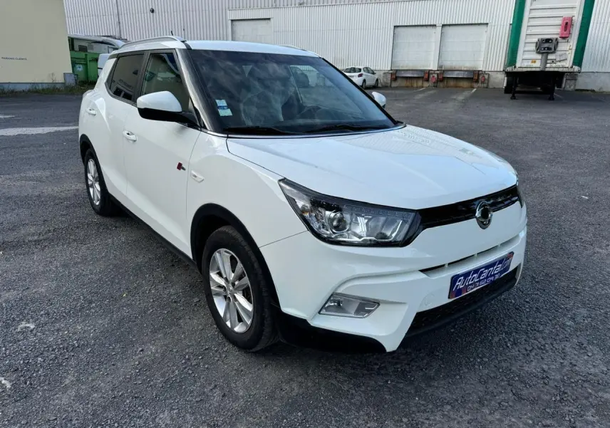 Vue 3/4 avant gauche d'un Ssangyong Tivoli blanc 2016 avec calandre noire et jantes alliage argentées.