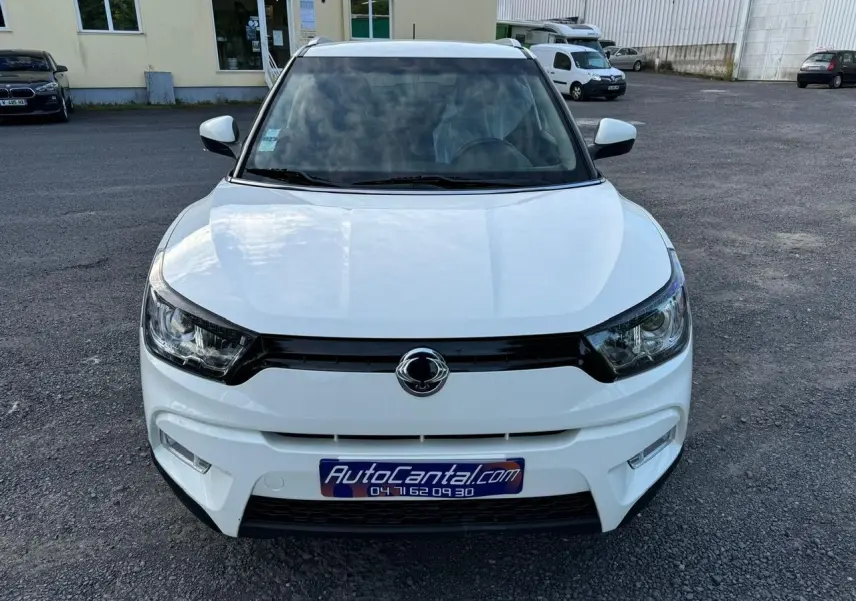 Vue frontale d'un SsangYong Tivoli blanc 2016 avec calandre noire et logo centré sur parking.