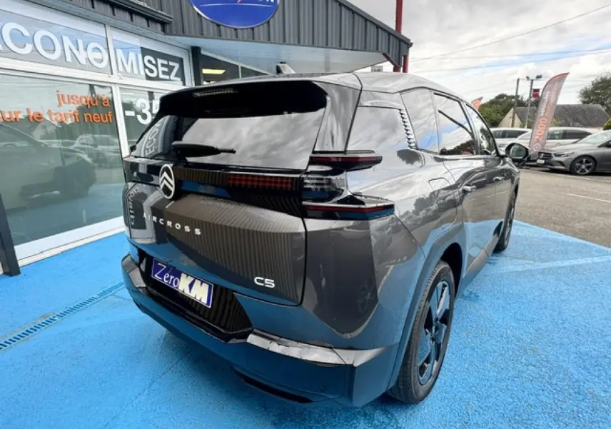 Vue 3/4 arrière d’un Citroën C5 Aircross gris Platinium avec feux arrière LED et jantes alu noires.